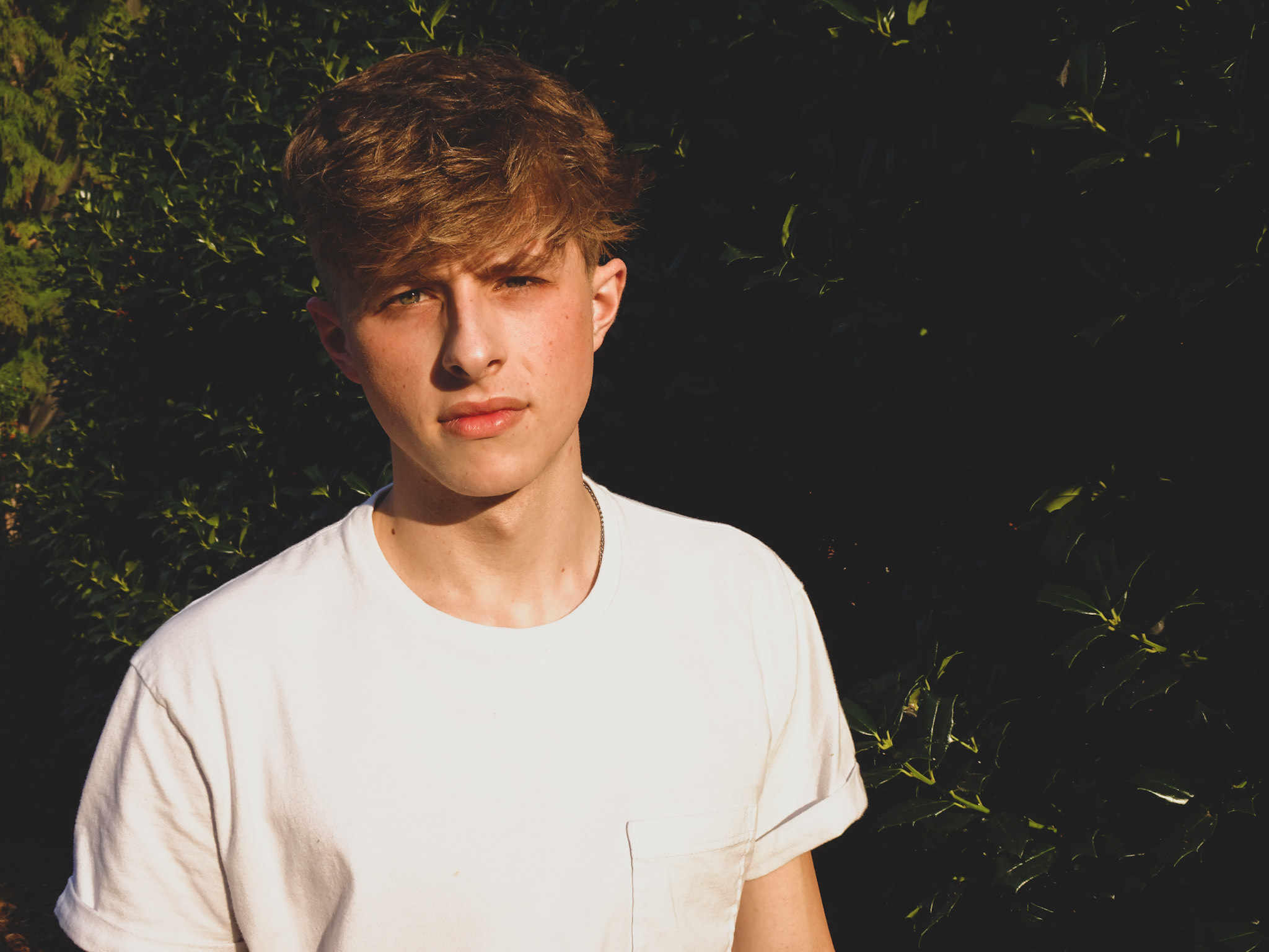 Picture of a man with shrubbery behind him